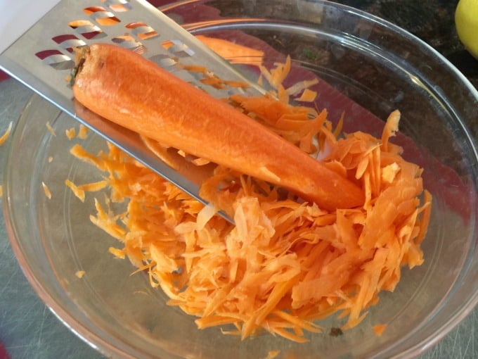 Grating Carrots into a clear glass bowl