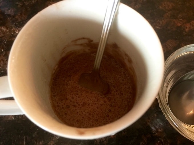 Stirring together cake mix and water with a fork in a mug