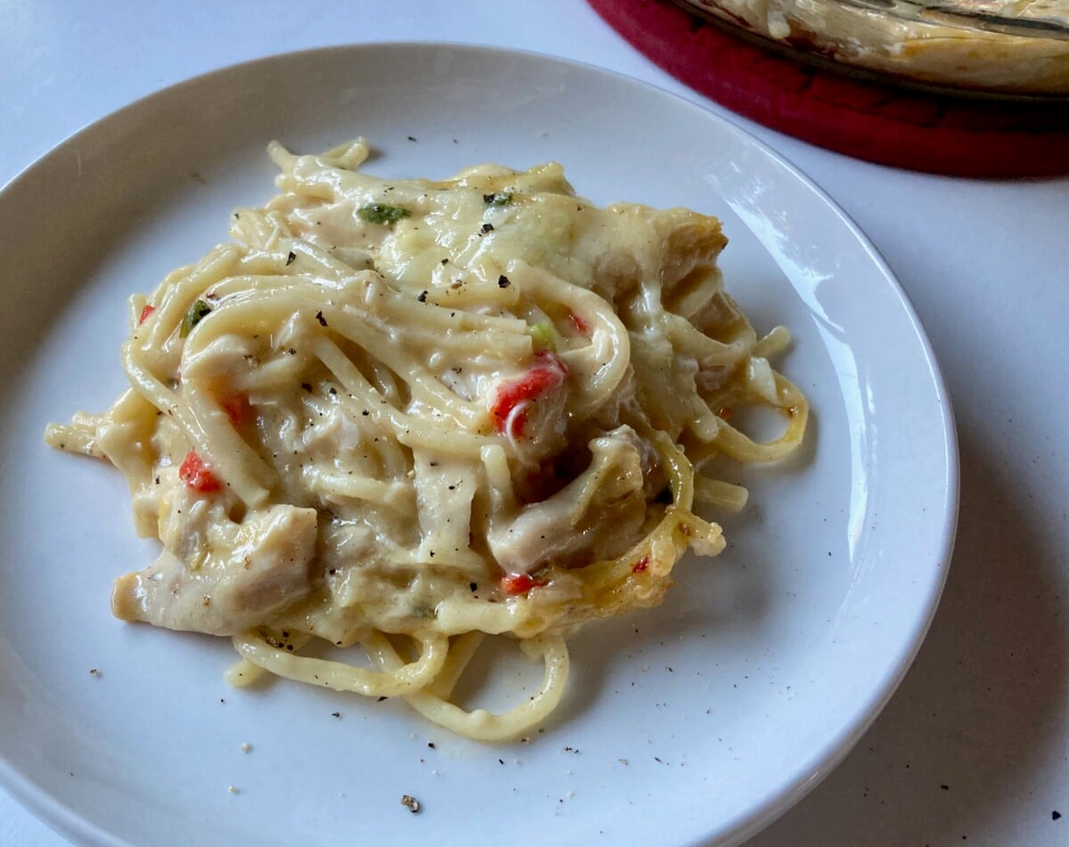 Chicken Spaghetti on White Plate with Casserole Dish in Background