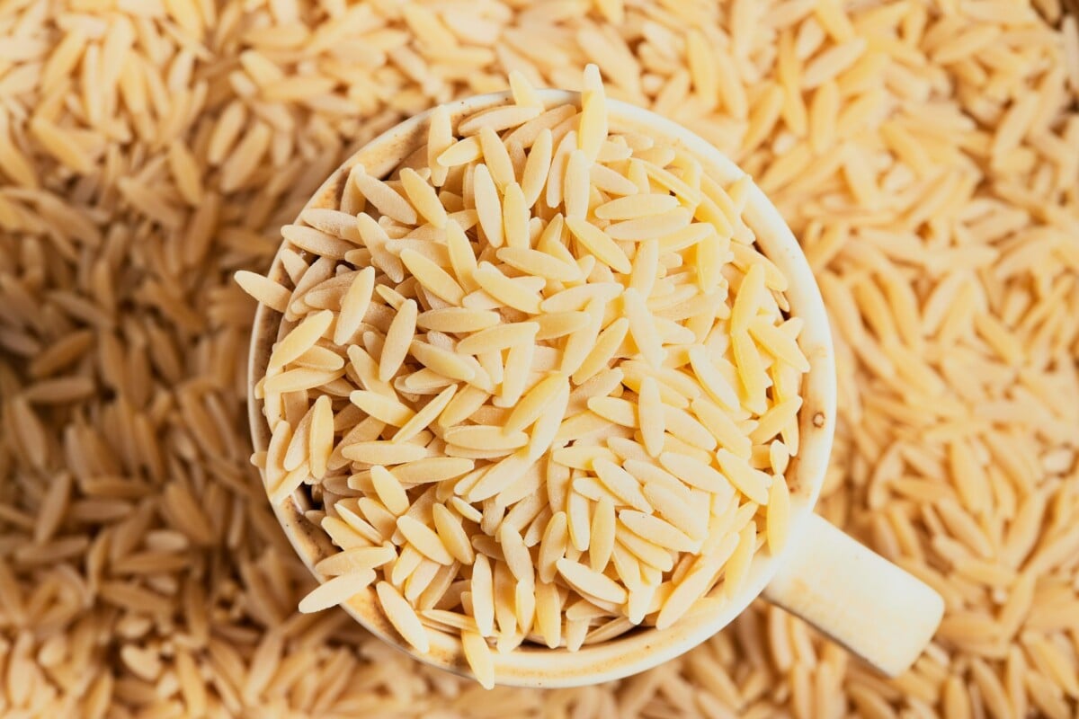 cup of orzo on top of pile of orzo shot from above 