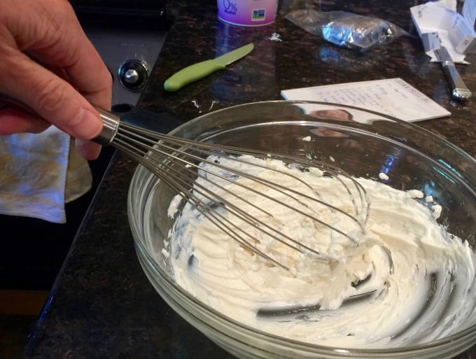 Combining creamy grape salad dressing in bowl with whisk
