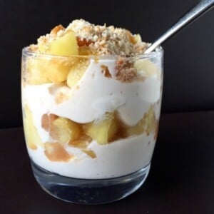 low calorie apple pie breakfast parfait in a clear glass front shot dark background