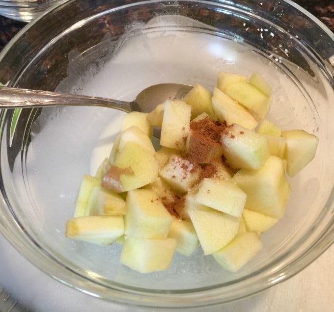 Apples, cornstarch, cinnamon, water in a clear bowl