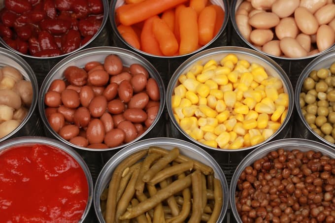 Different kinds of vegetables such as corn, peas and tomatoes in cans