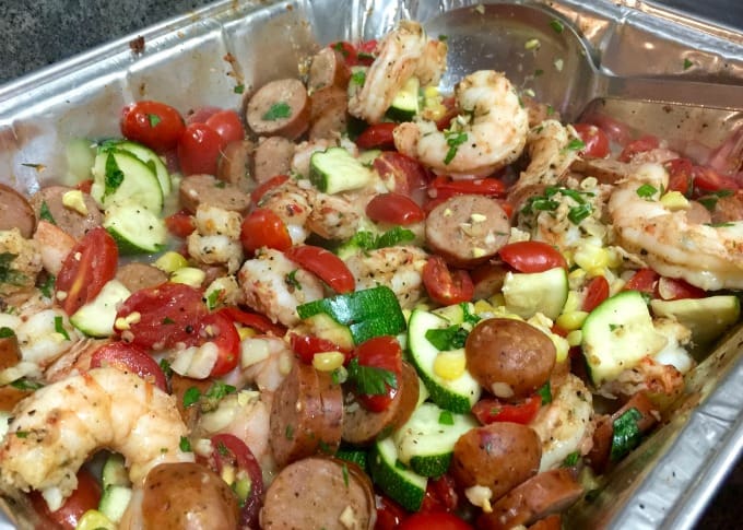 shrimp, sausage, corn, zucchini, tomatoes and spiced in aluminum foil pan