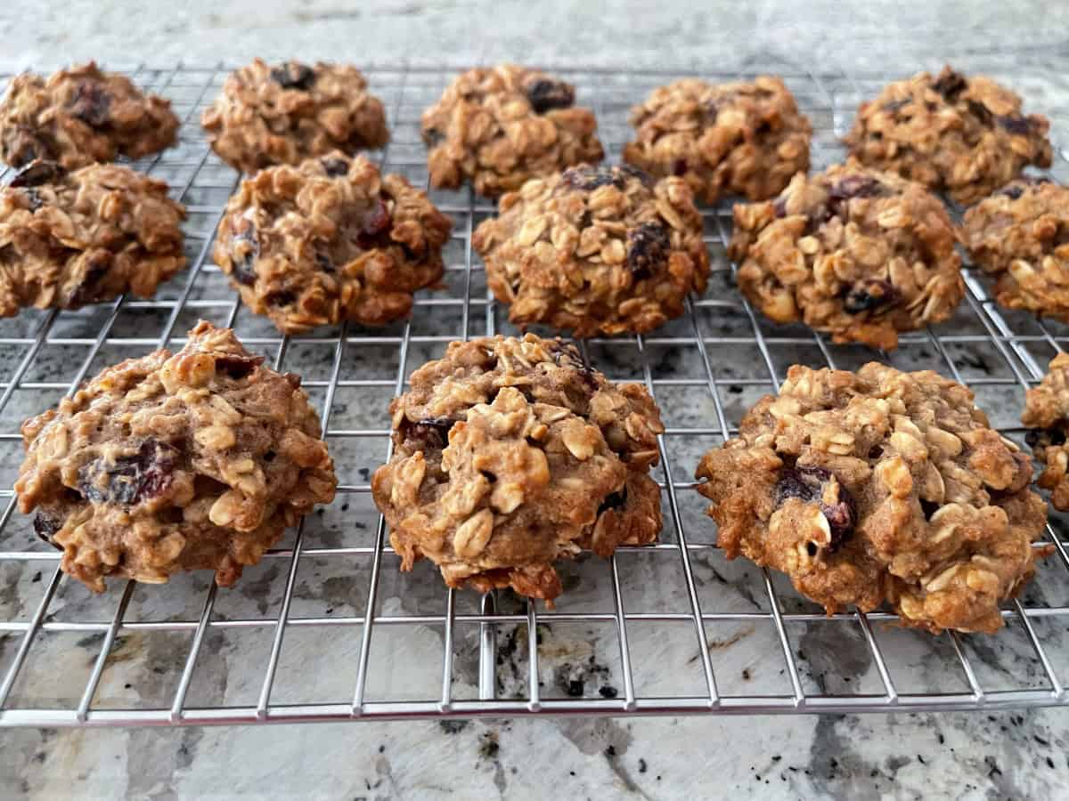 Applesauce oatmeal cookies with dried cranberries cooling on wire rack.