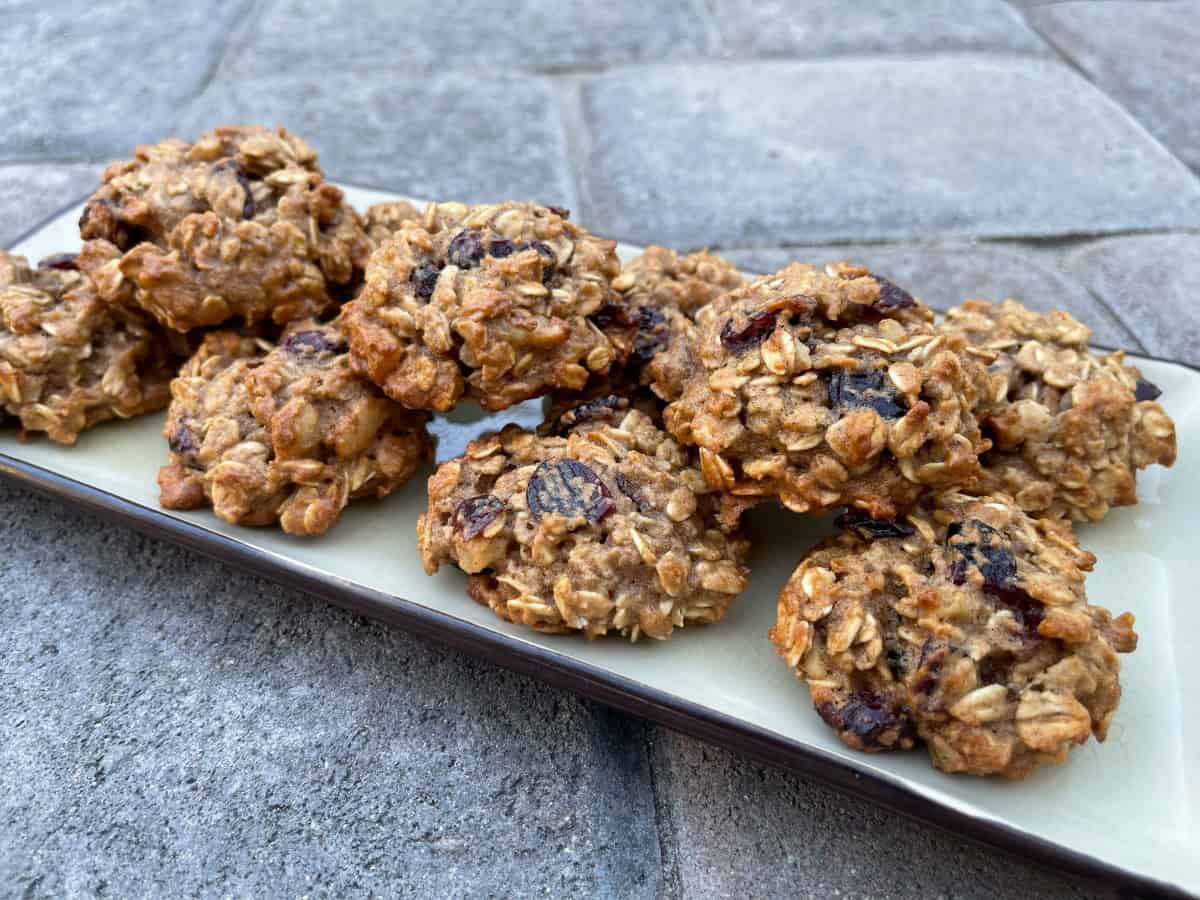 Applesauce Oatmeal Cookies with dried cranberries stacked on serving platter.