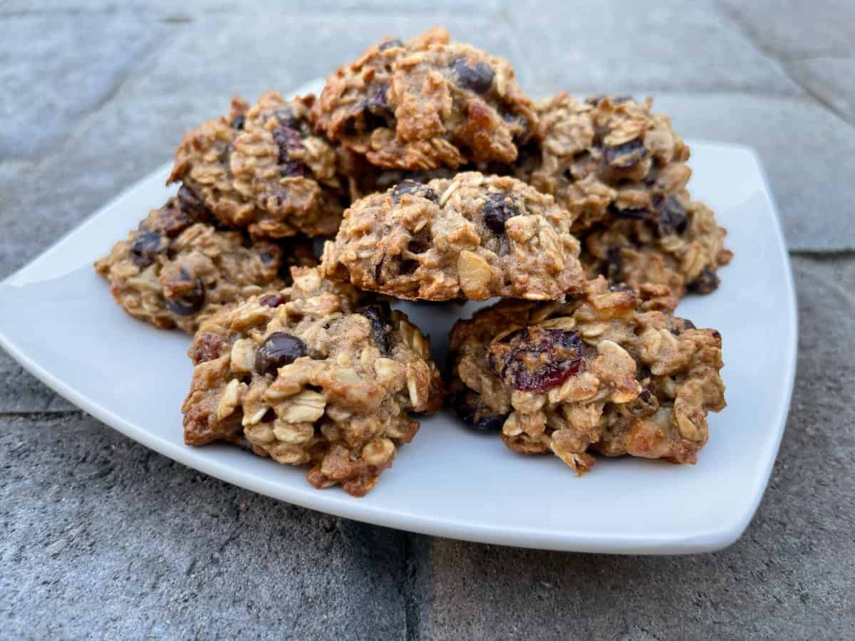 Applesauce Oatmeal Cookies with dried cranberries and chocolate chips stacked on white plate.