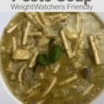 Flat white rimmed bowl filled with Italian Zucchini Pesto Soup with text overlay for Pinterest PIN