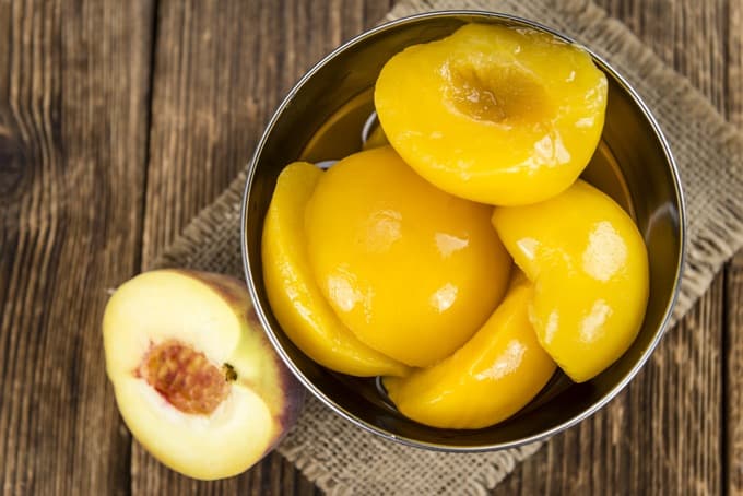 Preserved Canned Peaches on an old wooden table from above