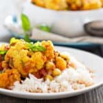 healthy vegan cauliflower curry on rice white plate