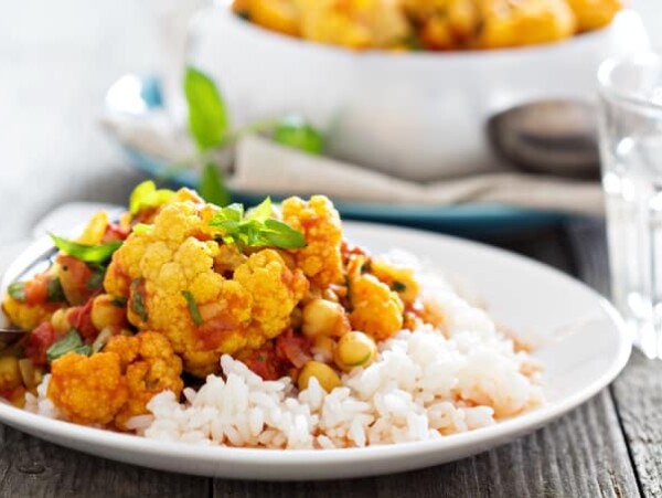 healthy vegan cauliflower curry on rice white plate