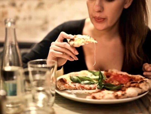young woman eating pizza