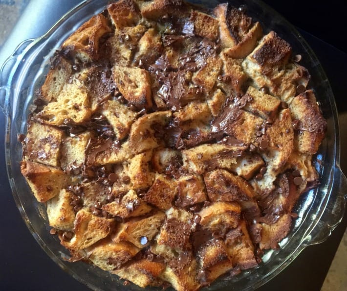 Chocolate banana bread pudding in glass pie dish fresh from the oven.
