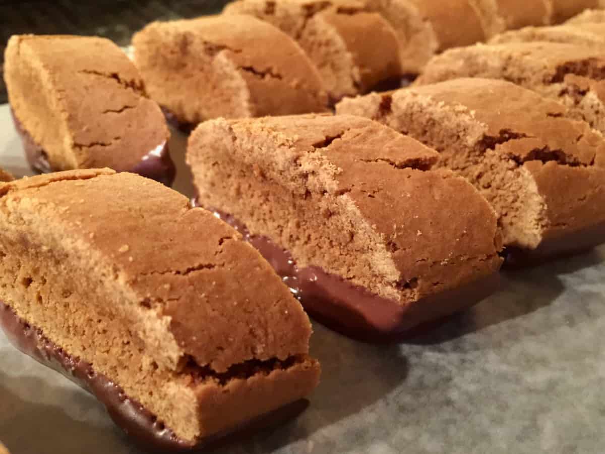 Chocolate dipped molasses cookies on parchment paper.