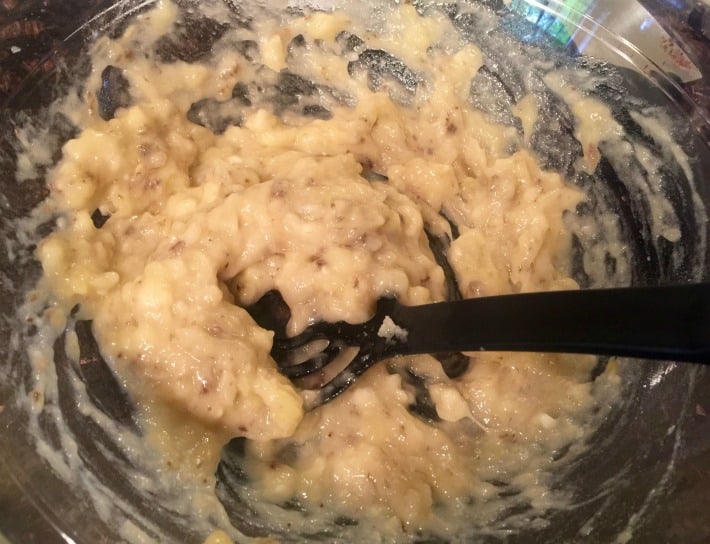 Glass bowl with mashed ripe bananas.