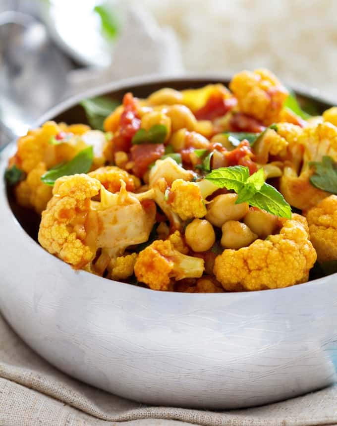 Vegan curry with chickpeas and cauliflower in a silver bowl