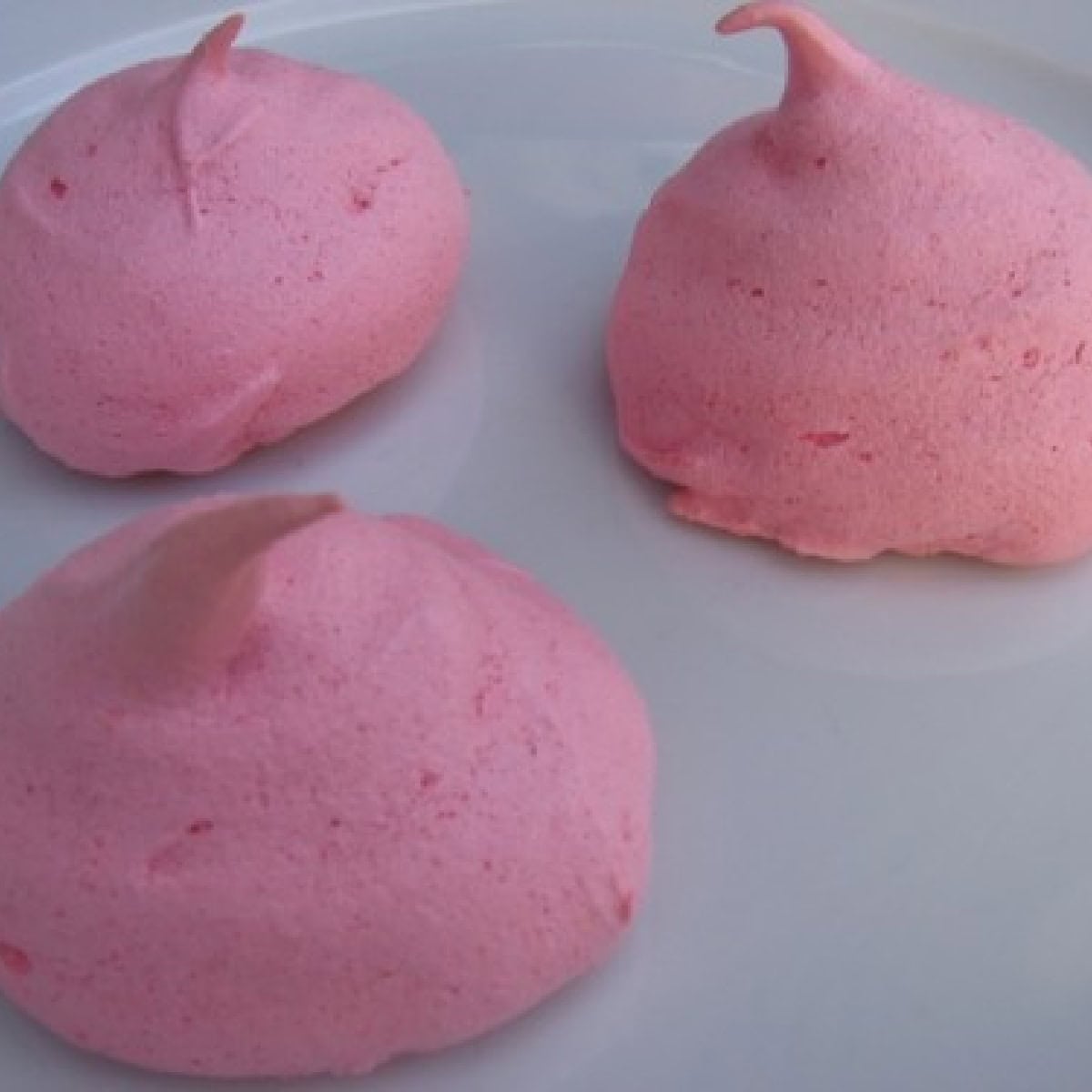 Raspberry Jello Meringue Kiss Cookies on white plate.