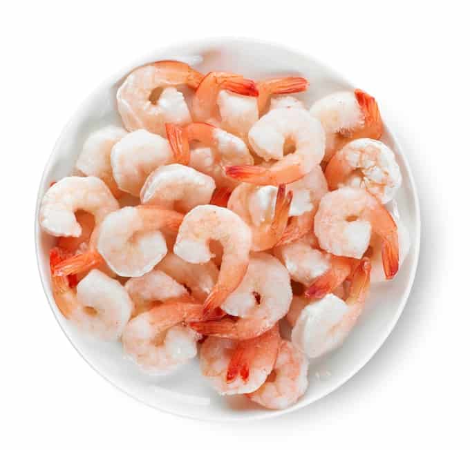 Plate of frozen prawns in white bowl.