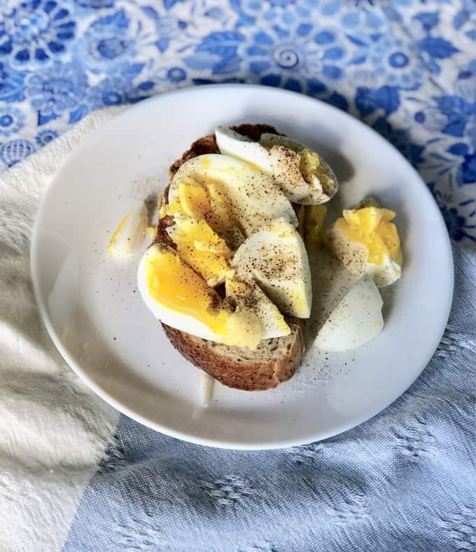 Soft Boiled Egg with salt and pepper on Toast on table with blue tablecloth