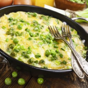 tortilla pan filled with pea omelet with forks arranged atop