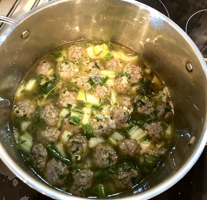 Soup pot with sausage balls and bok choy for wonton soup