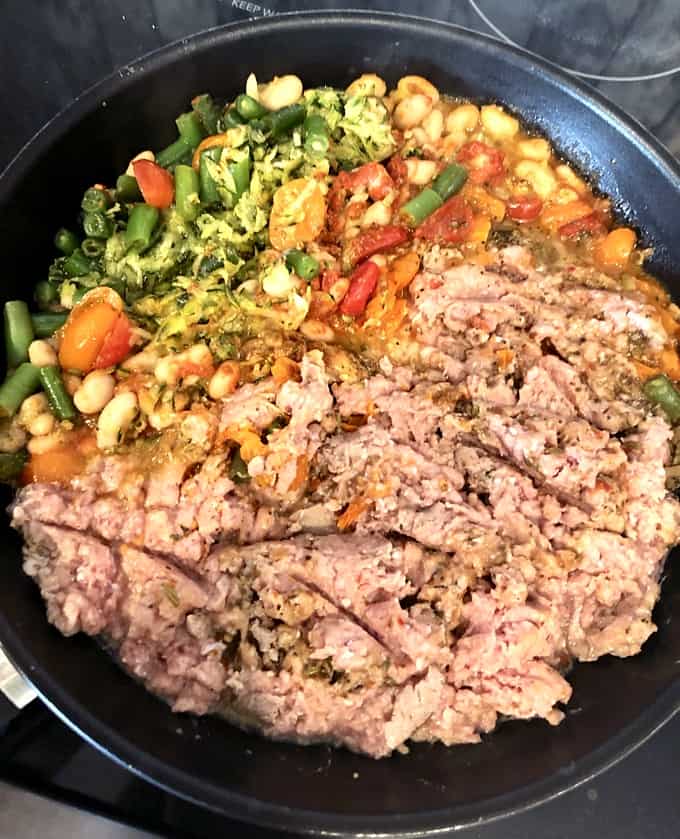 Skillet with ground turkey, shredded zucchini, green beans, tomatoes and Italian spiced.