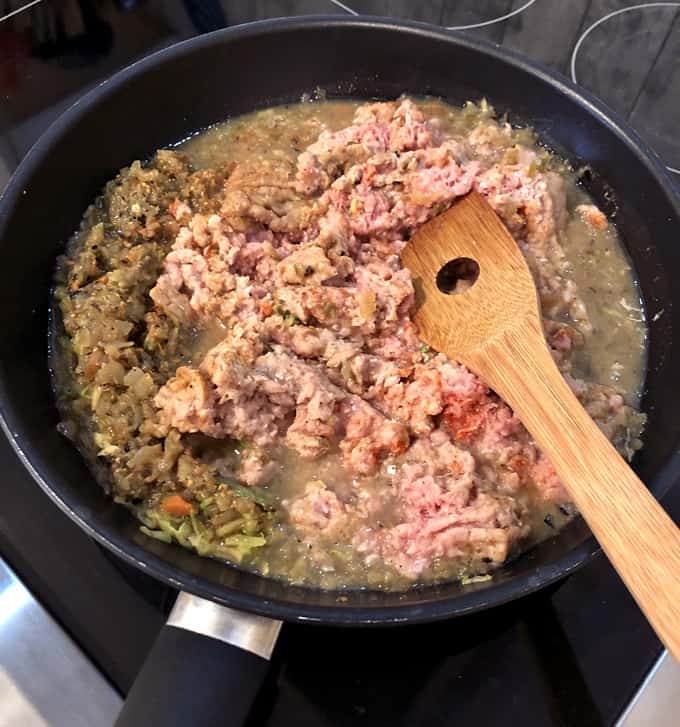 Cooking Green Chili Ground Turkey in a skillet with a bamboo spatula