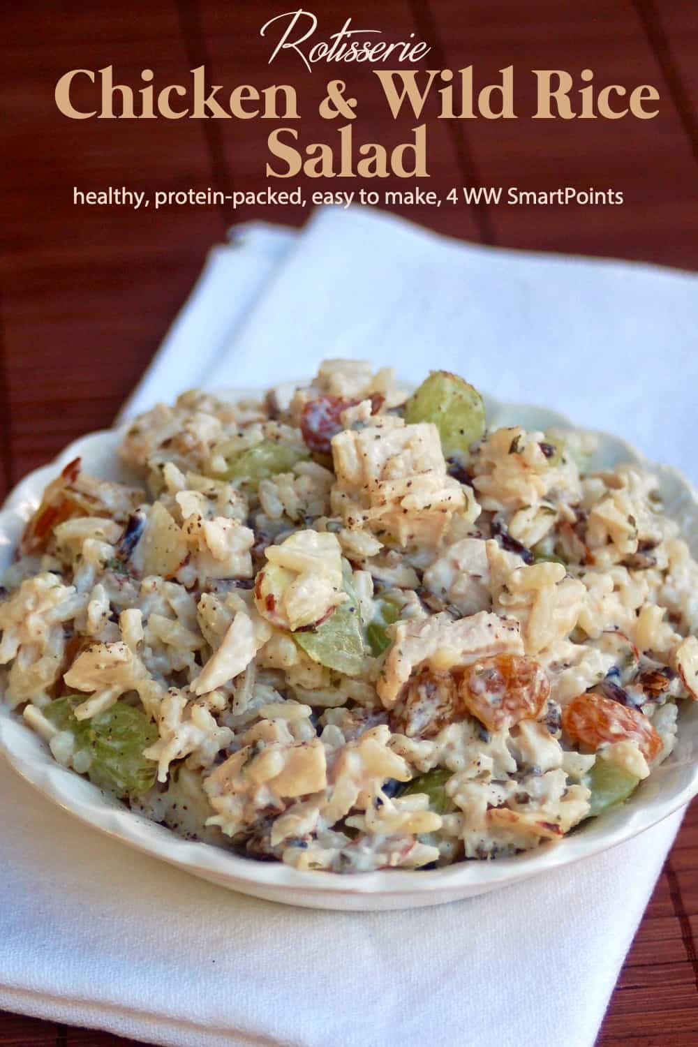 Rotisserie chicken salad with wild rice, grapes and almonds in white serving bowl