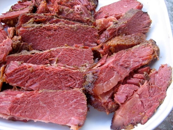 Slices of maple mustard corned beef on a white platter