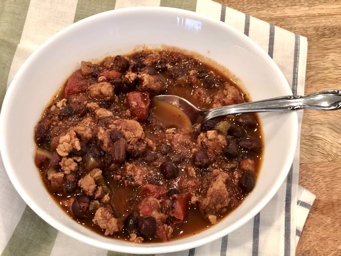 Bowl of Tex-Mex Turkey Chili with Beans in a white bowl with spoon
