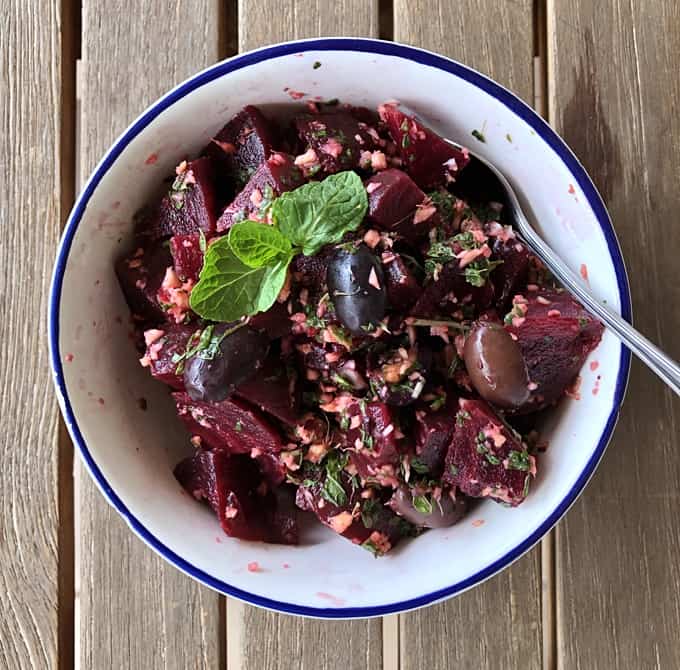 Provencal beet salad with Mediterranean black olives and mint in serving bowl.