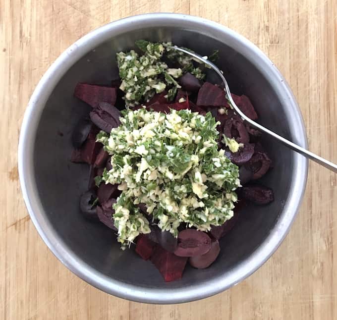 Beets and olives in mixing bowl with garlic, ginger and mint.