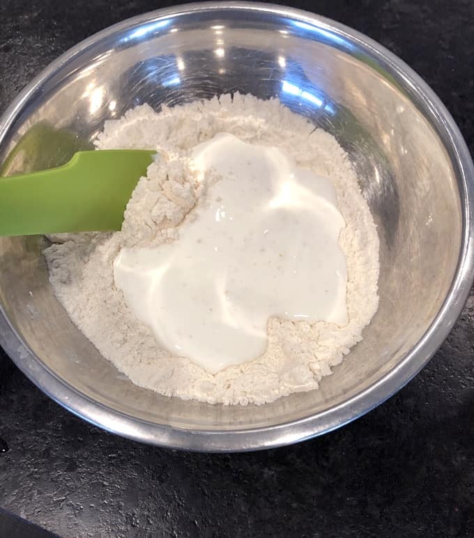 Mixing wet ingredients into dry flour mixture for making scones