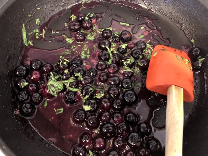 Cooking blueberry sauce with fresh blueberries, tarragon, apple juice, rice wine vinegar and dijon mustard.