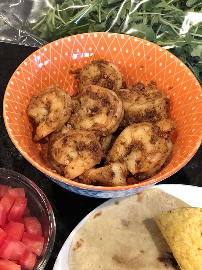 Spiced shrimp, diced tomatoes, arugula and tortillas for soft shrimp tacos