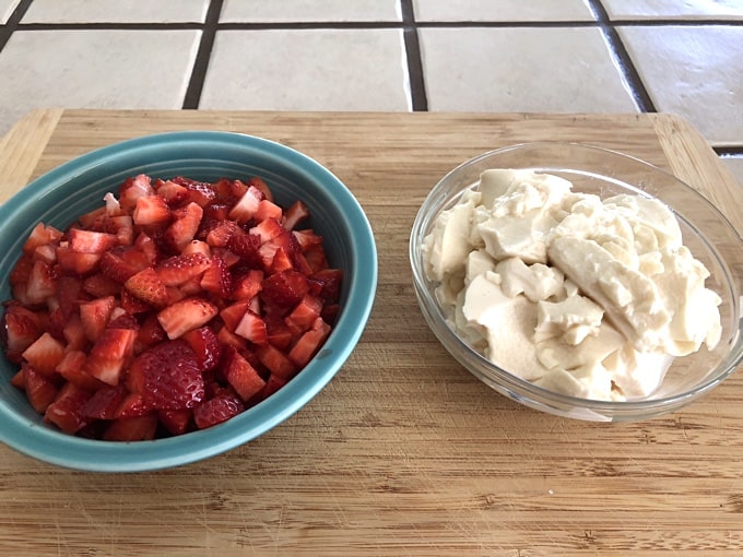 Bowl of chopped fresh strawberries and bowl of drained silken tofu.