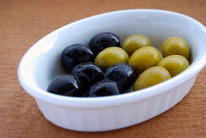 Black and green olives in small white bowl.