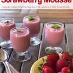 Creamy Strawberry Mousse topped with fresh mint near a plate with whole fresh strawberries.