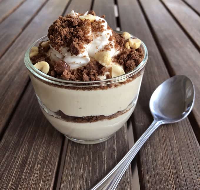 Chocolate peanut butter pie in a mug topped with crushed graham crackers and chopped peanuts.