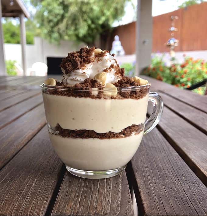 Chocolate Peanut Butter Pie with whipped topping, crushed graham crackers and chopped peanuts in dessert glass.
