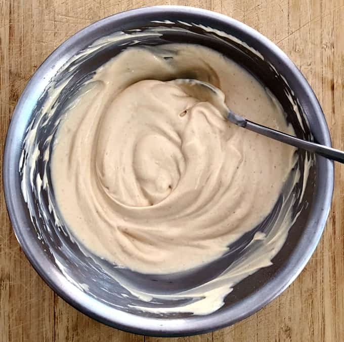 Peanut butter powder mixed with Greek yogurt in small bowl.