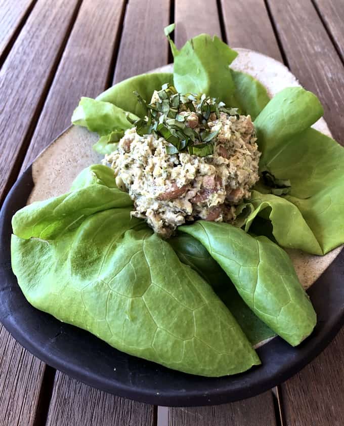 Tuna white bean salad on butter lettuce on ceramic plate.