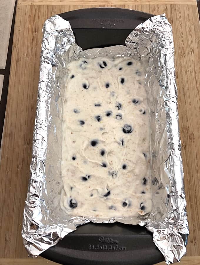 Lemon-blueberry cheesecake yogurt mixture in foil-lined loaf pan.