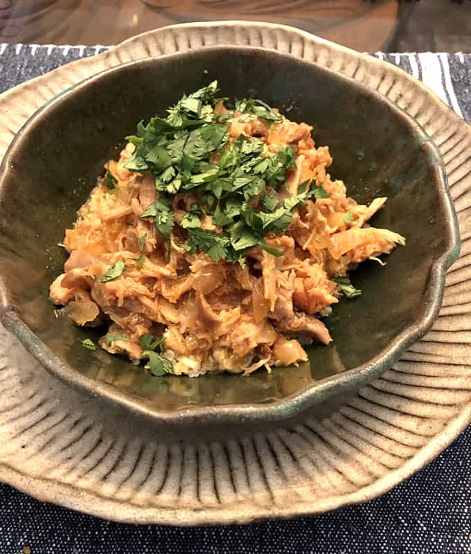 Slow cooker honey sriracha chicken quinoa bowl in green ceramic bowl.