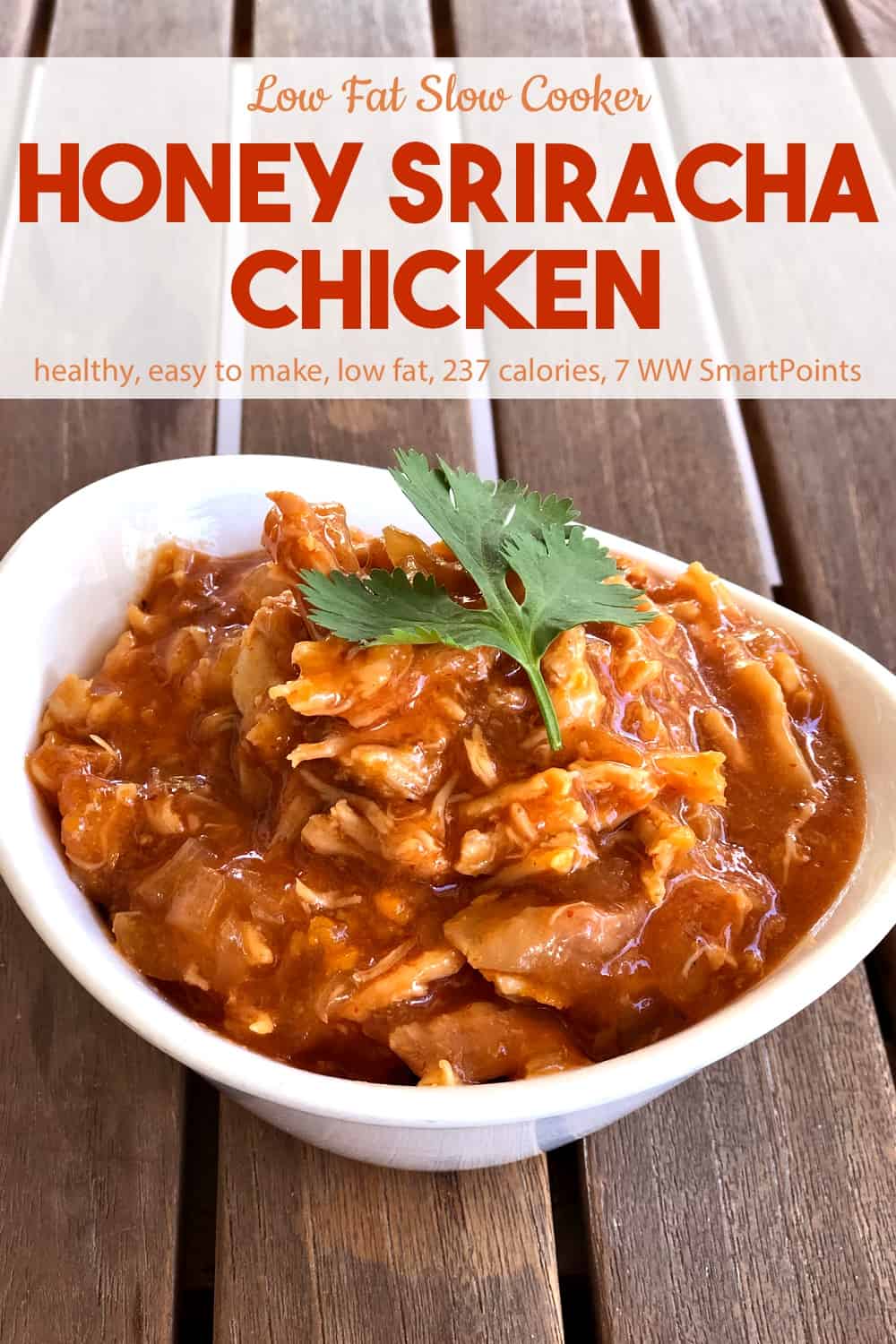 Low fat honey sriracha shredded chicken in a white bowl on a wood table.