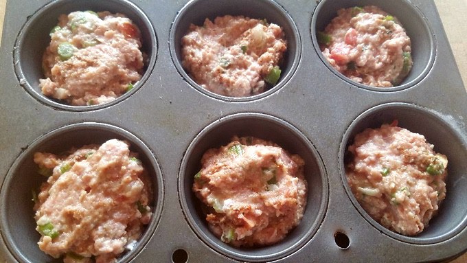 Meatloaf dividing among 6-cup muffin tin for making meatloaf muffins.