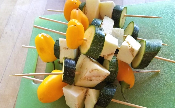 Bamboo skewers with sliced zucchini, chopped yellow peppers and cubed eggplant.
