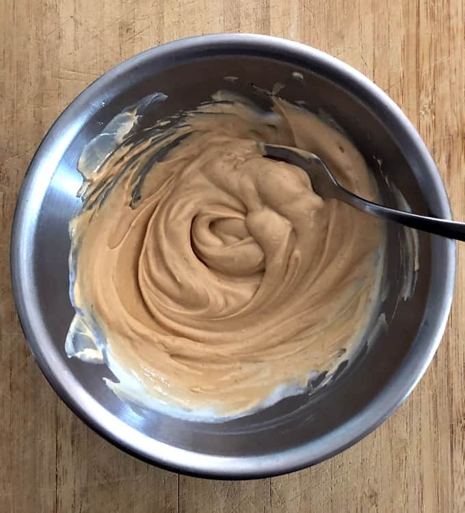 Mixing creamy peanut butter dip in stainless steel mixing bowl.