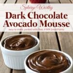 Creamy dark chocolate avocado mousse in white ramekins on wooden table with red candle.
